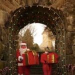 Santa and helper with presents under arch at Rockery in North Easton