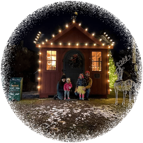 Family in front of Santa house snow frame